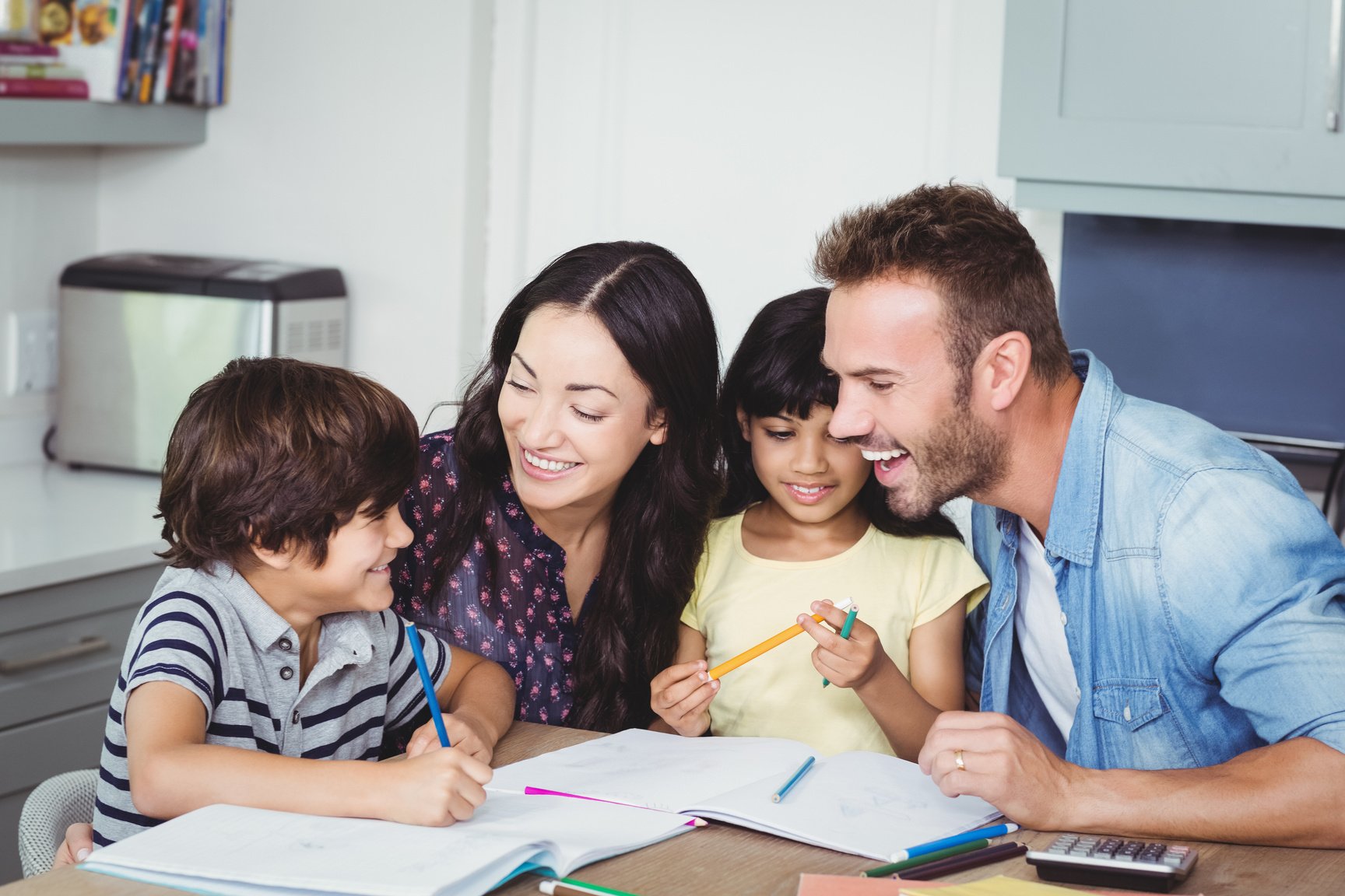 Cheerful parents assisting children in homework